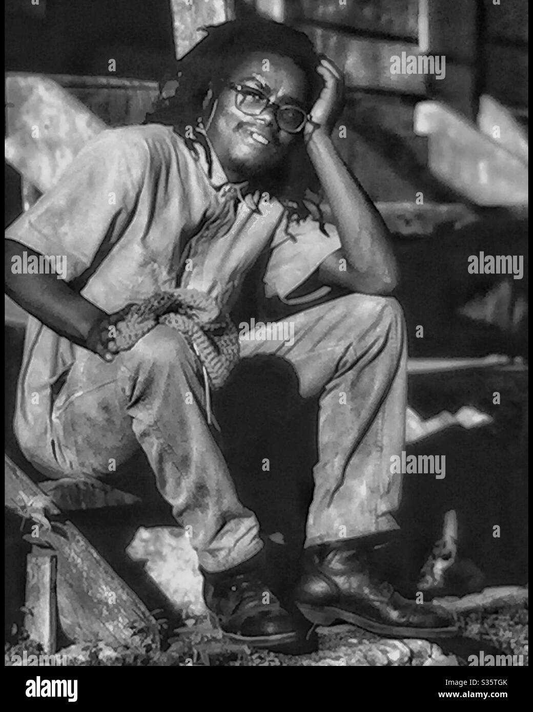 A smiling Jamaican male takes a rest on outside steps. - Smartphone Captured Stock Image