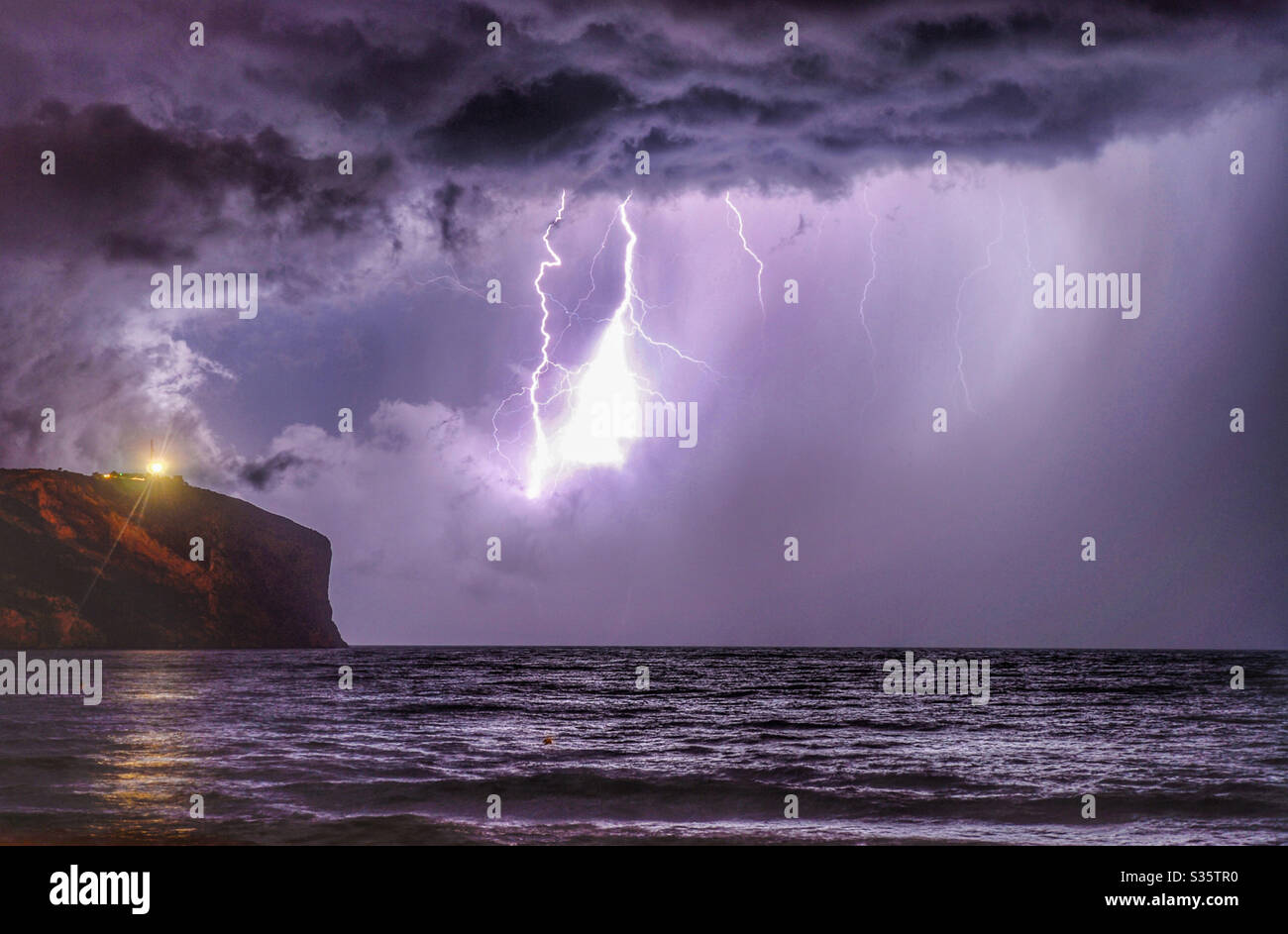 Electric storm with fork and sheet lightning over sea Stock Photo
