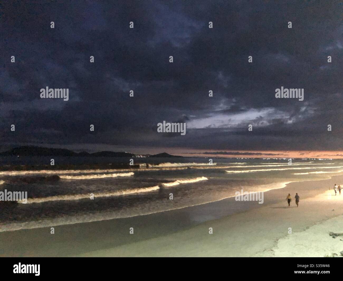 An evening stroll on the beach at night in Cabo Frio, Brazil. - Smartphone Captured Stock Image
