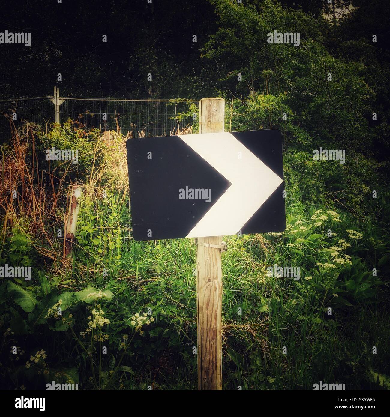 Bend in road traffic sign pointing to direction - Smartphone Captured Stock Image