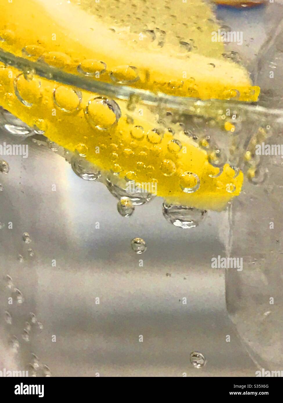 Slice of lemon floating on sparkling water - Smartphone Captured Stock Image