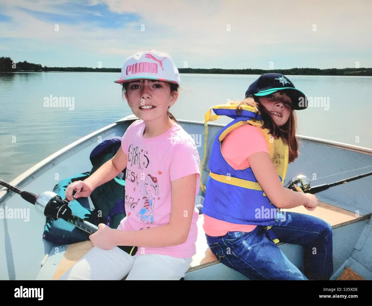 Family fun, Fishing on Pine Lake , Alberta, Canada, two sisters - Smartphone Captured Stock Image