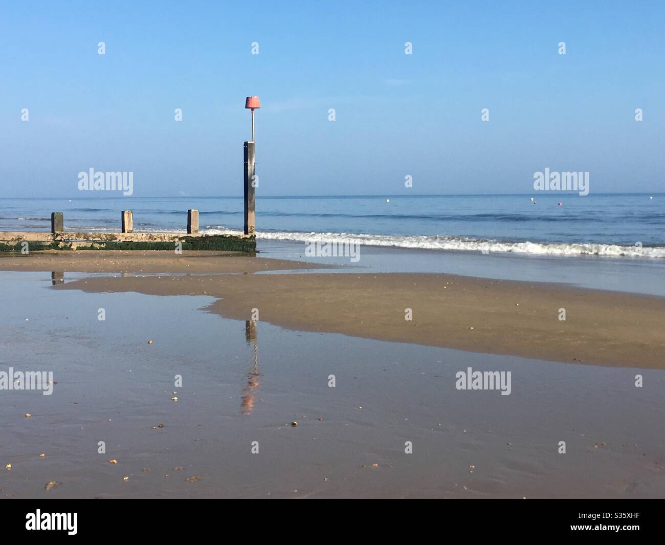 Reflection of a Groyne at low tide on Boscombe Beach, Bournemouth, Dorset Stock Photo