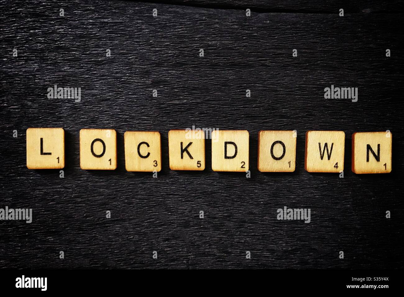 Wooden tiles spell out Lockdown. - Smartphone Captured Stock Image