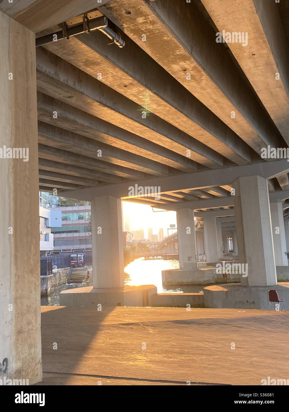 Ray of golden sunlight taking from below a highway bridge Stock Photo
