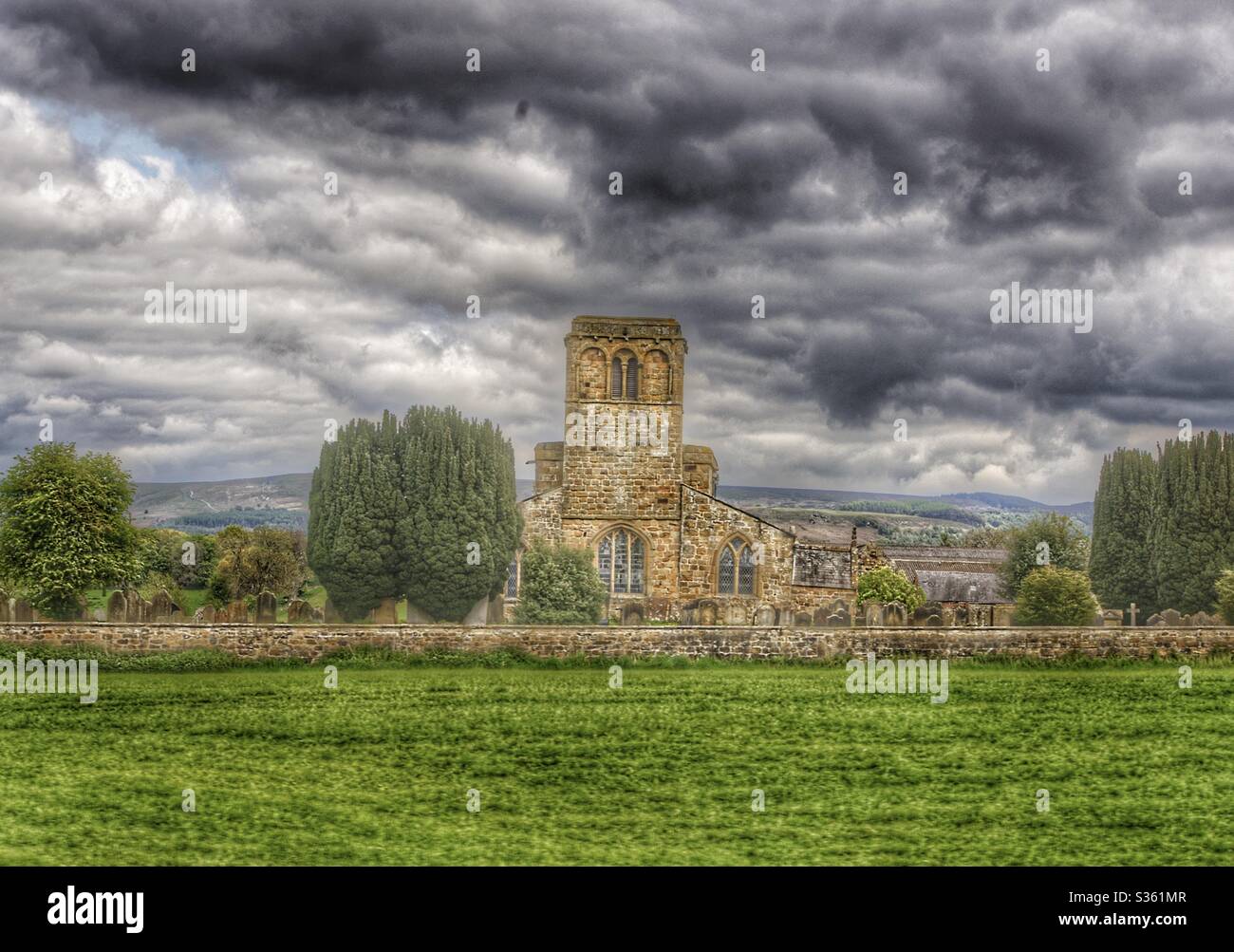 Church with dark grey clouds captured in north Yorkshire Stock Photo