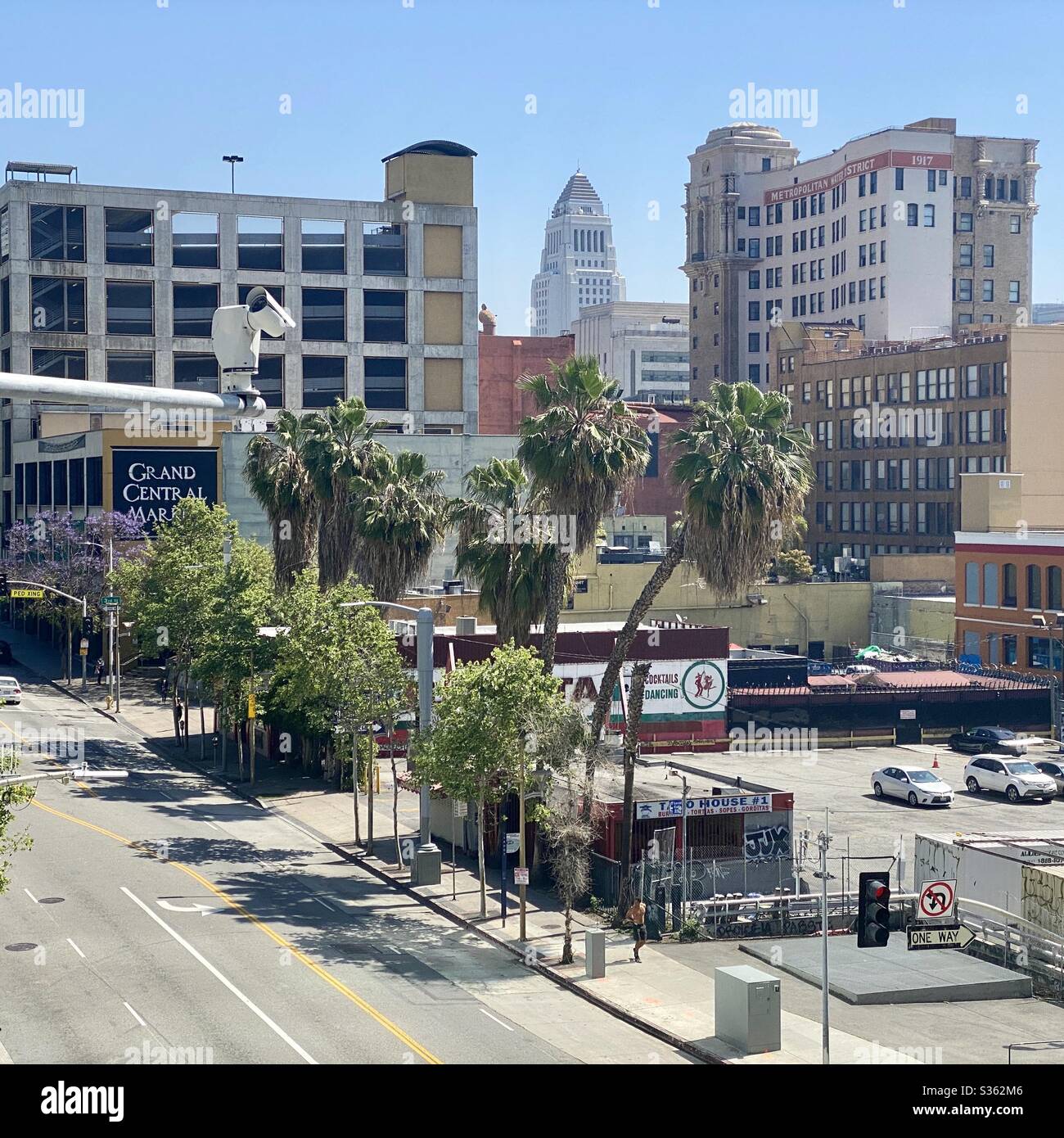 LOS ANGELES, CA, APR 2020: Downtown view looking past Grand Central Market towards City Hall, security camera on pole in foreground Stock Photo