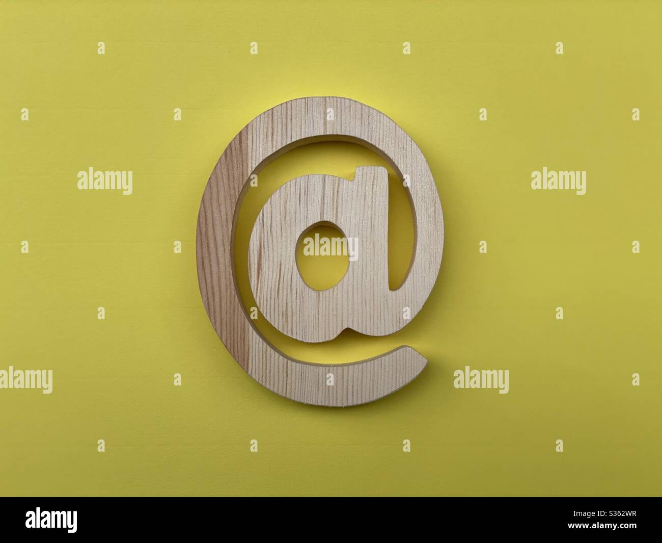 Wooden At Symbol Email on yellow background - Smartphone Captured Stock Image
