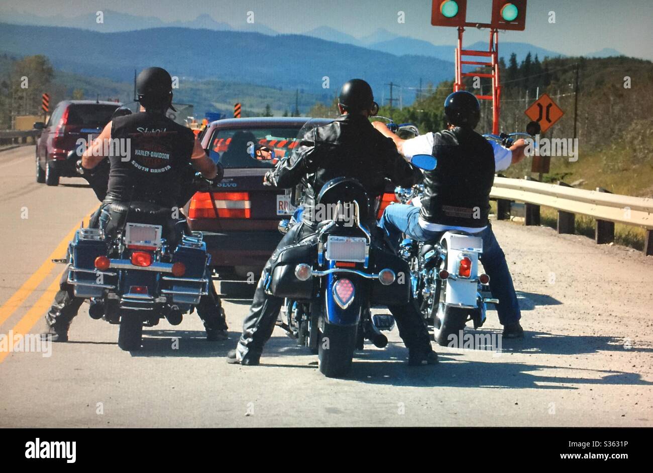 Three motor cyclers, three motorcycles, waiting at the stop light , Alberta, Canada - Smartphone Captured Stock Image