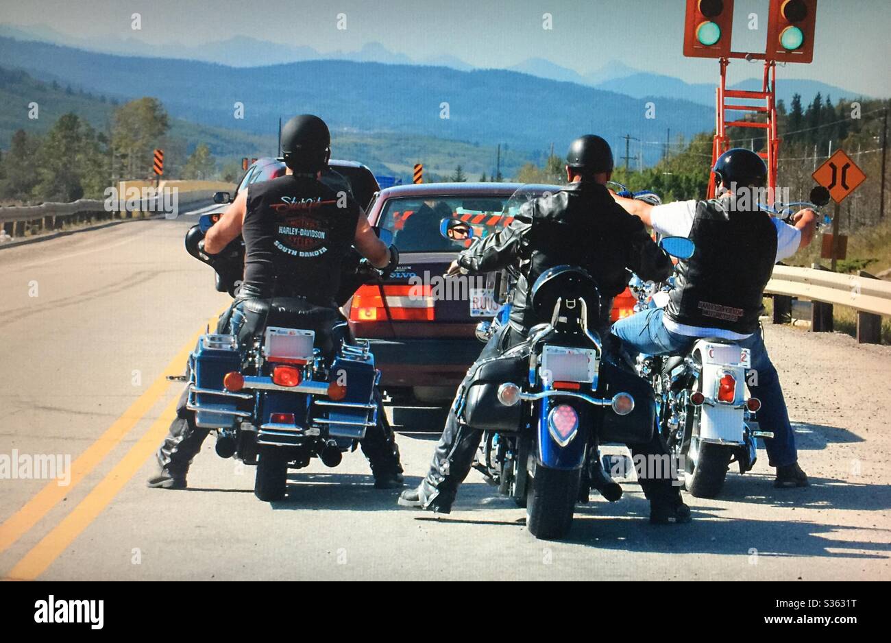 Three motor cyclers, three motorcycles, waiting at the stop light , Alberta, Canada - Smartphone Captured Stock Image