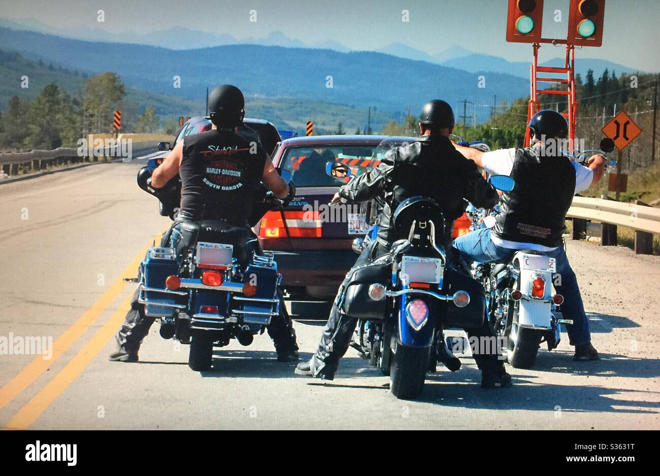 Three motor cyclers, three motorcycles, waiting at the stop light , Alberta, Canada Stock Photo