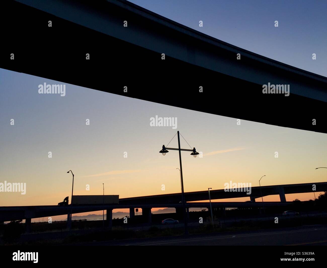 Silhouette of a semi-truck on highway overpass at dusk, Emeryville, California, USA. - Smartphone Captured Stock Image