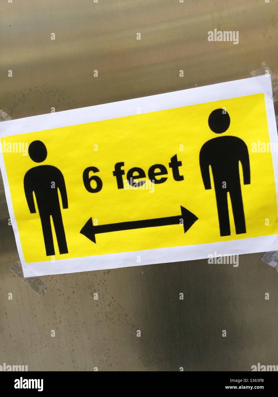 Sign asking for 6 feet between bodies to prevent the spread of infection during the coronavirus pandemic, 2020, NYC, USA - Smartphone Captured Stock Image