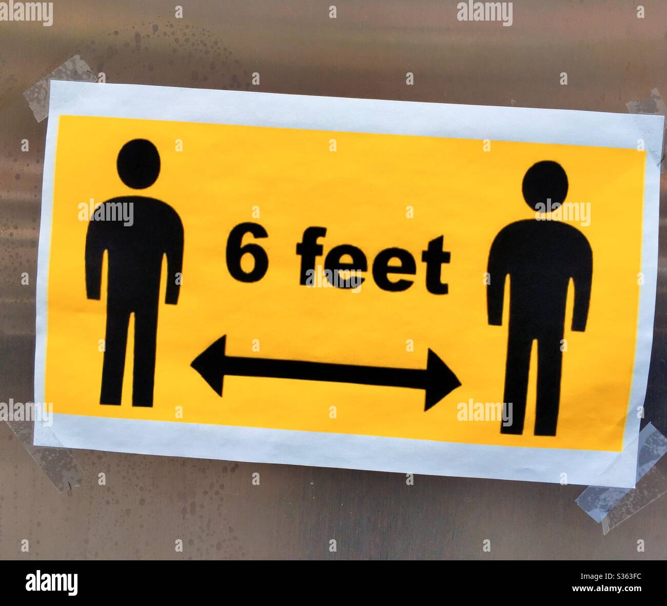 Pictogram sign of social distancing as required by directives to fight the COVID-19 spread of infection, 2020, NYC, USA - Smartphone Captured Stock Image