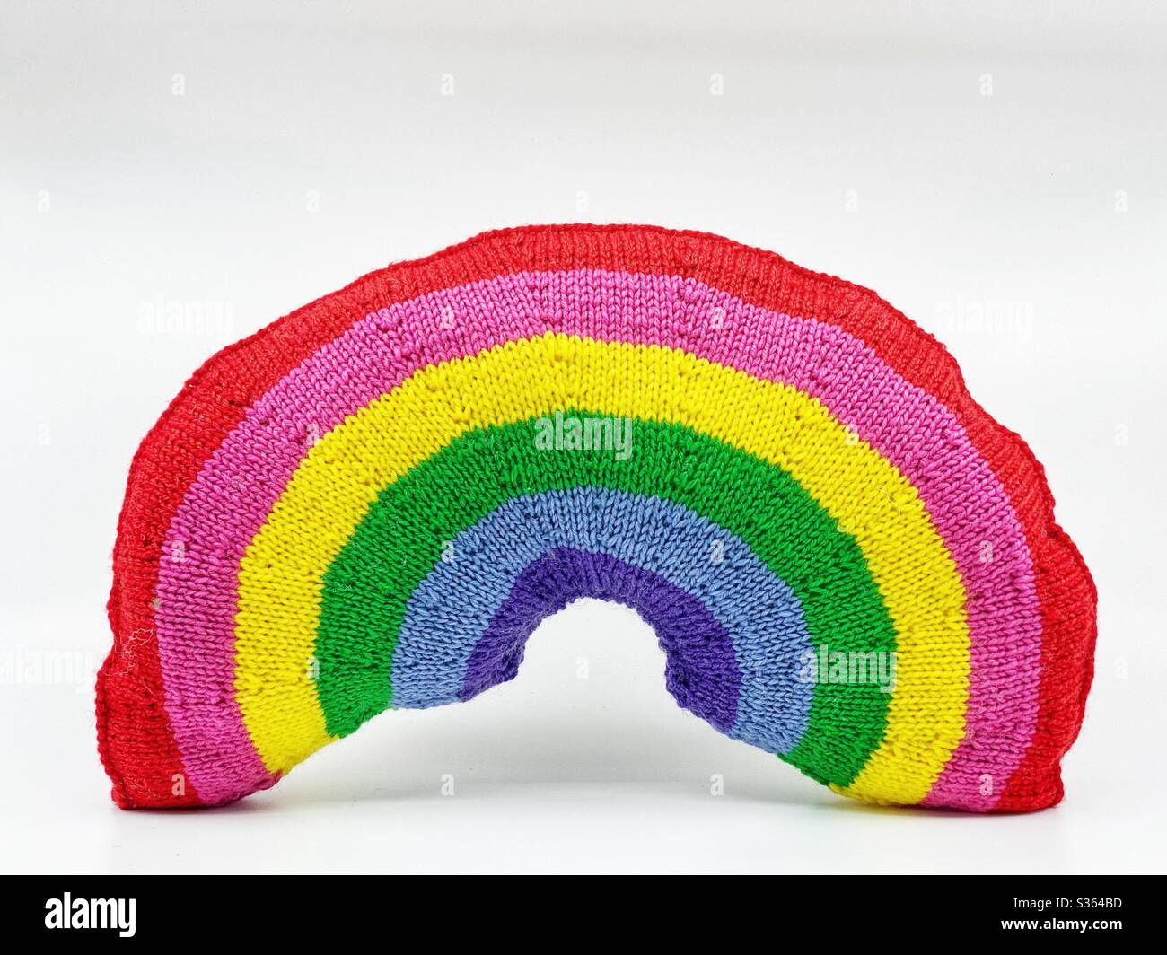 Knitted rainbow cushion isolated on white background. Space for copy. - Smartphone Captured Stock Image
