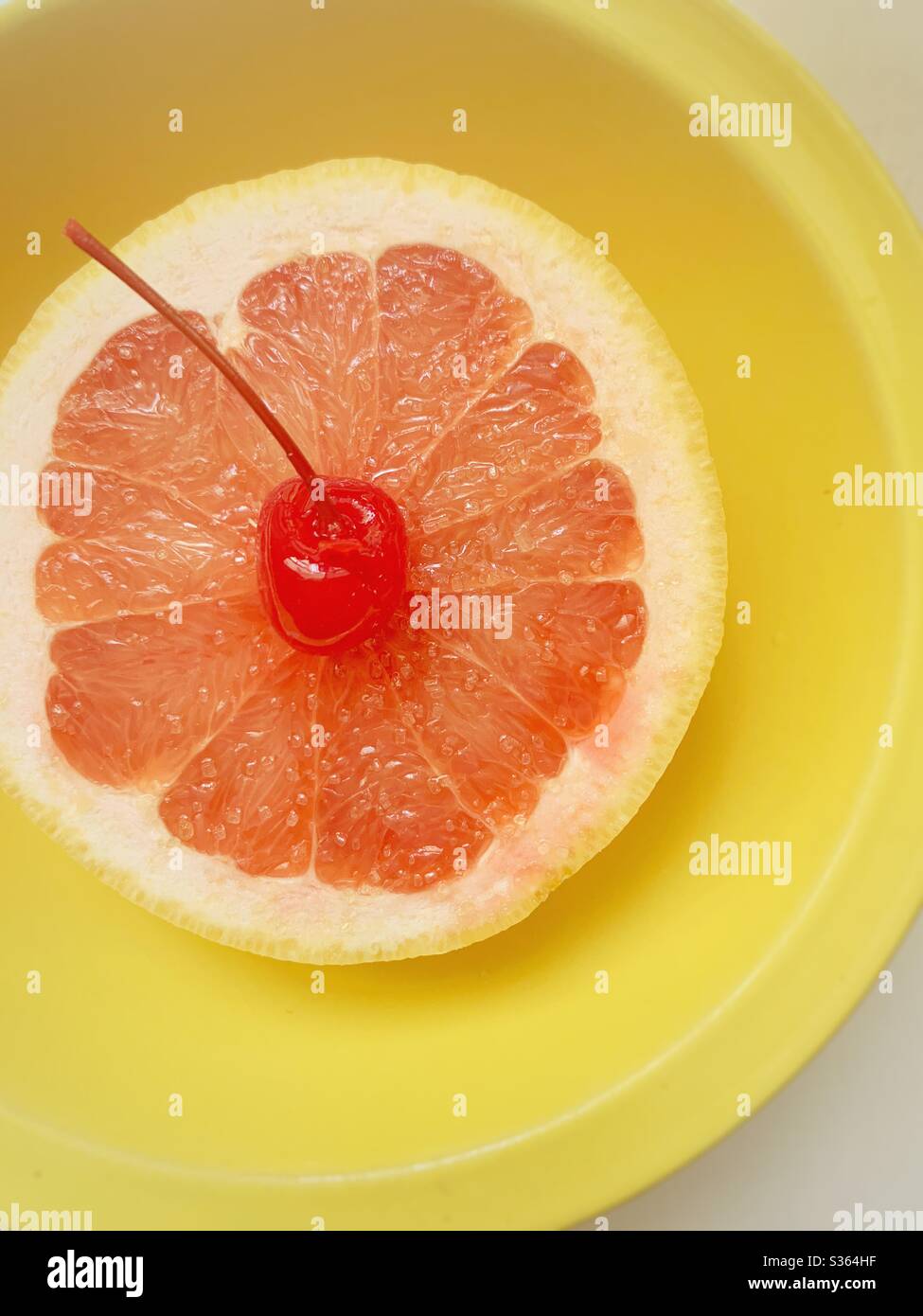Grapefruit in a yellow bowl with a cherry - Smartphone Captured Stock Image