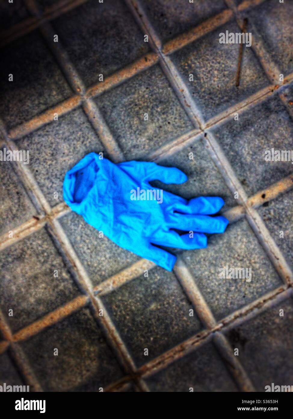 Protective blue gloves abandoned on the street Stock Photo