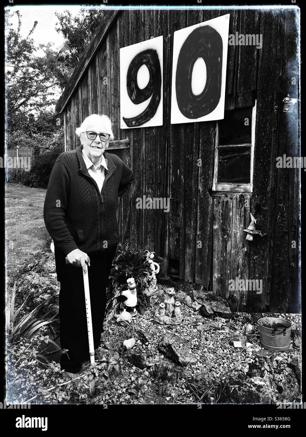 Woman celebrating her 90th birthday in isolation in her garden during the coronavirus lockdown 2020 - Smartphone Captured Stock Image