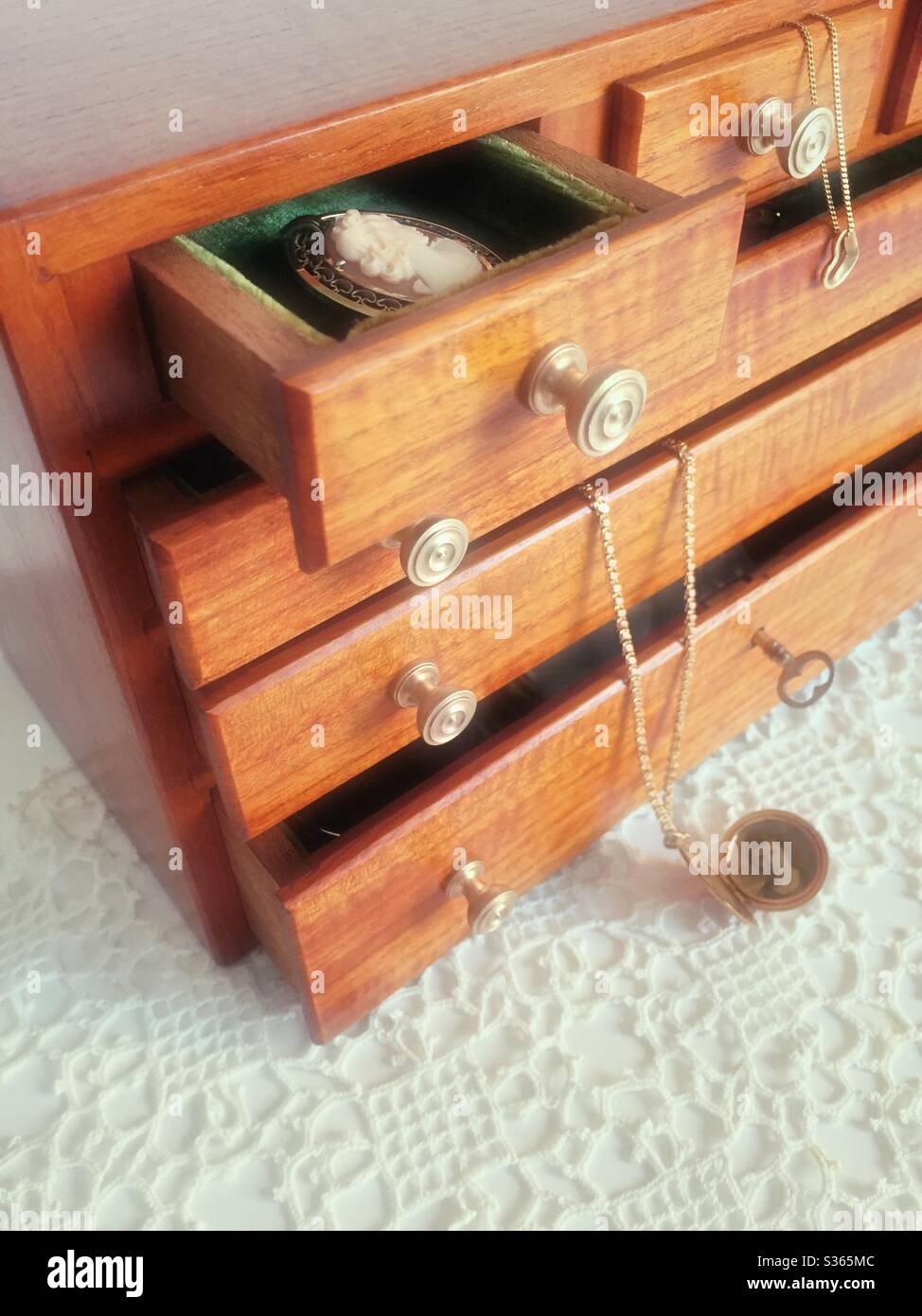 Vintage handcrafted wooden jewelry box with open drawers and jewelry