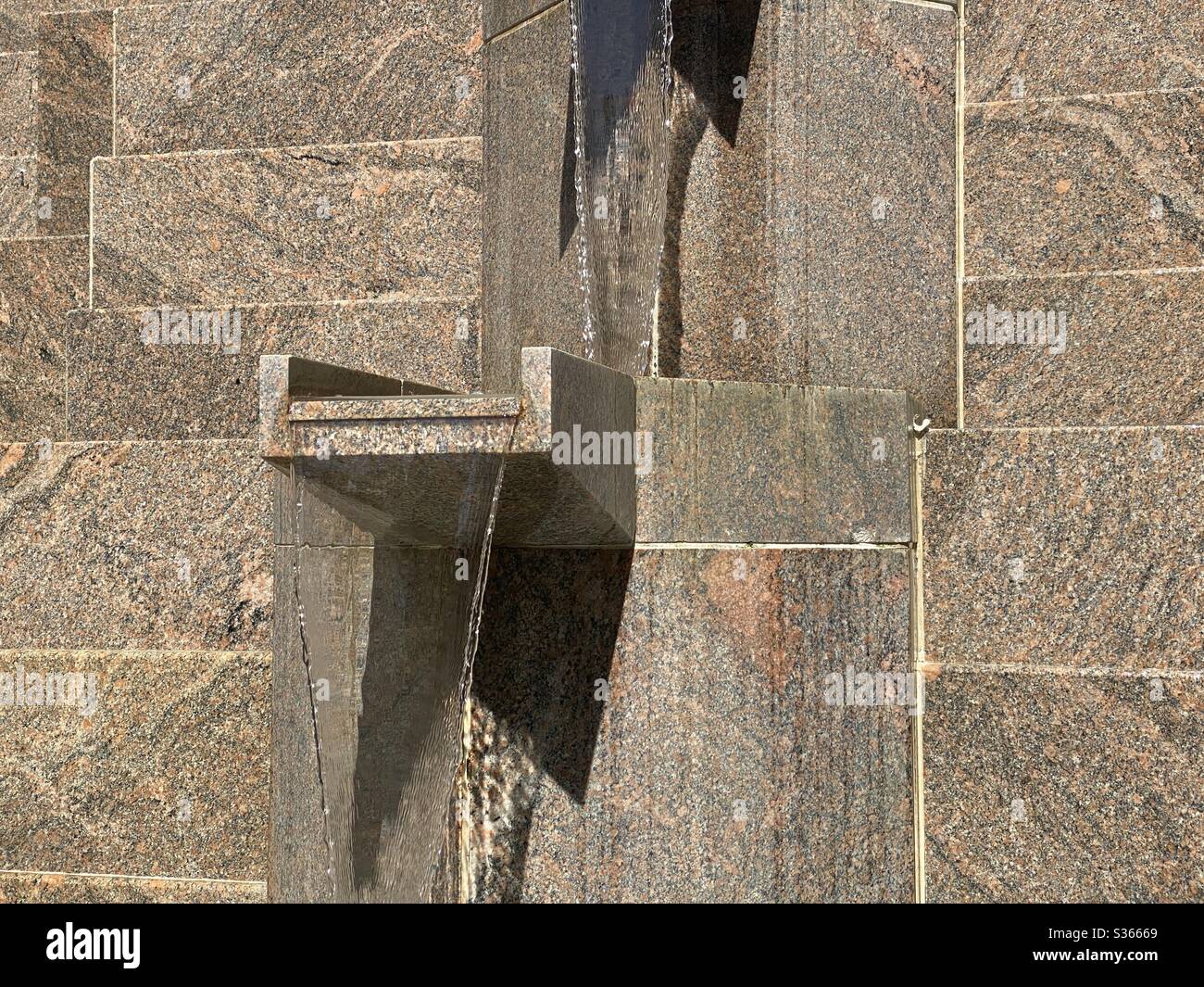 Detail of modern fountain with water falling from stone platforms, creating abstract background texture for text and graphics - Smartphone Captured Stock Image Detail of modern fountain with water falling from stone platforms, creating abstract background texture for text and graphics - Smartphone Captured Stock Image
