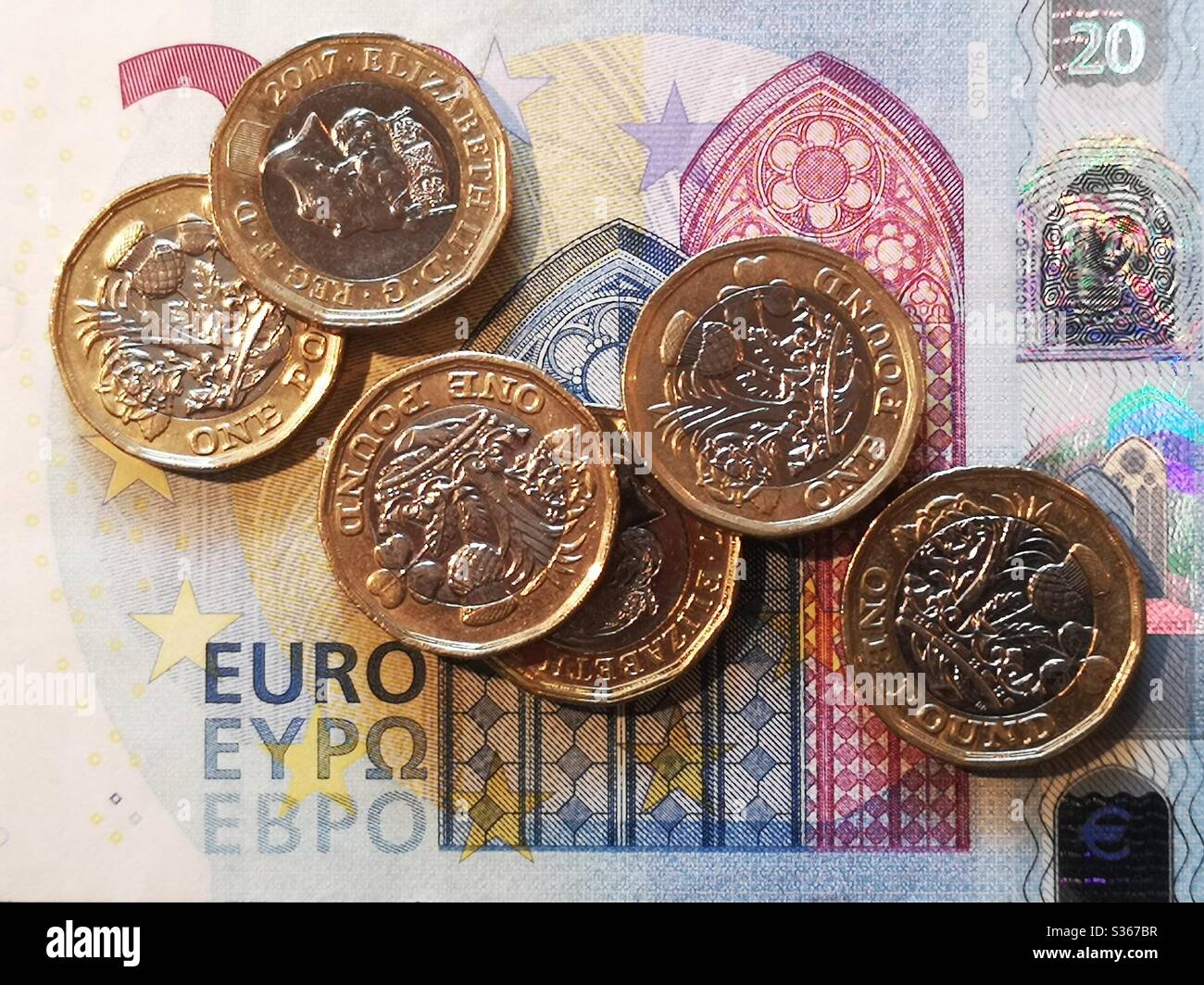 Pound coins on 20 euro note Stock Photo