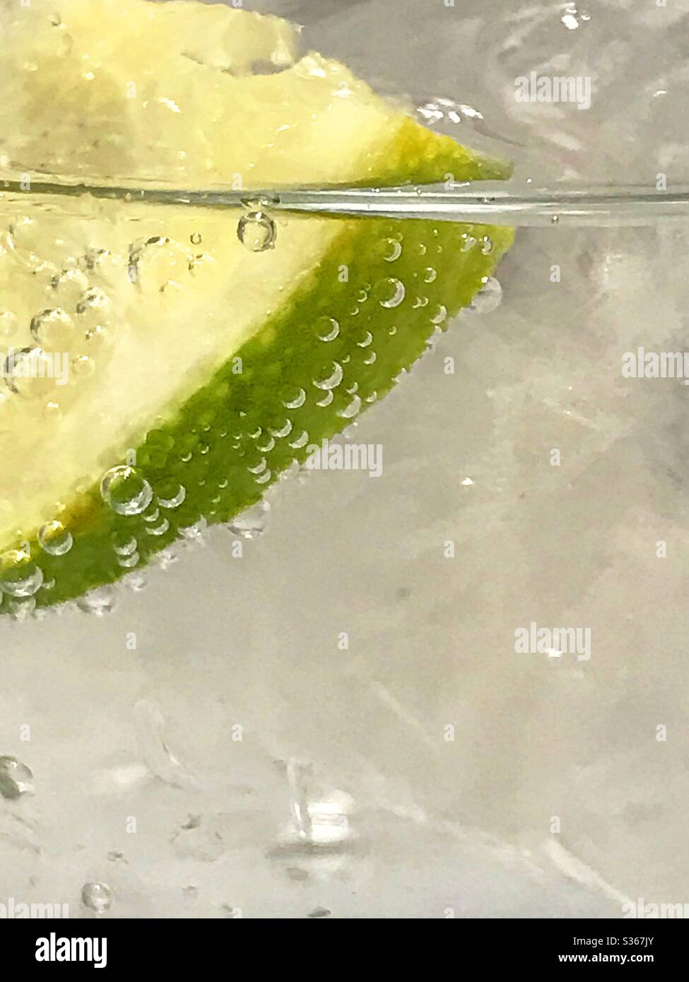 Lemon slice floating in sparkling water - Smartphone Captured Stock Image