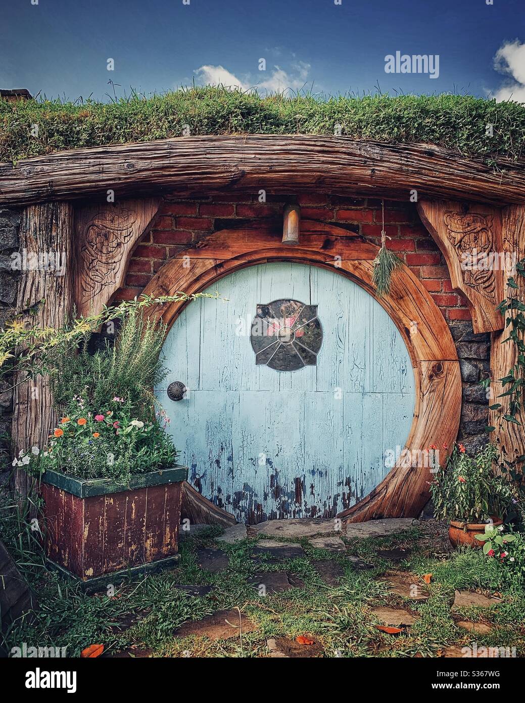 Hobbiton. Bucolic place in New Zealand where the hobbits from the Middle Earth live. Lord of the rings movie set. Blue round door Stock Photo