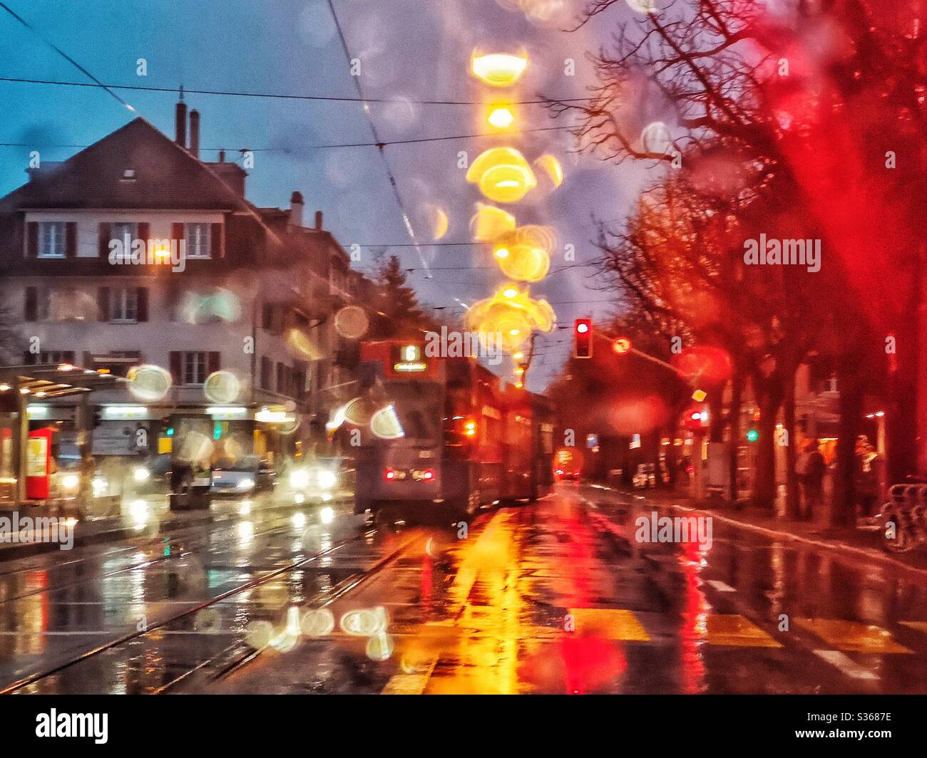 Rainy streets at night, with tram, streetlights... - Smartphone Captured Stock Image