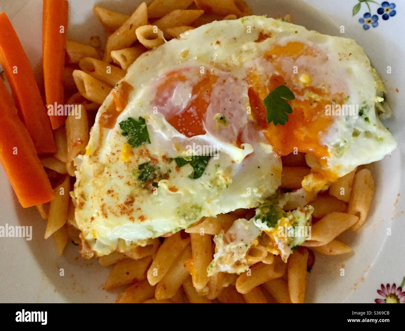 Eggs over easy on Penne pasta with Italian parley - Smartphone Captured Stock Image