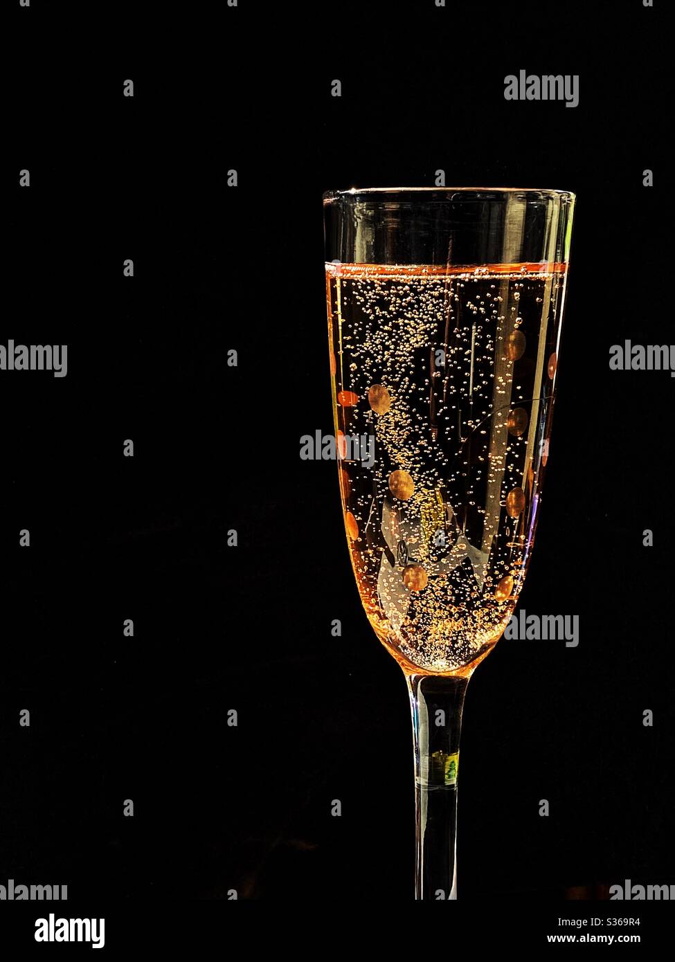 Glass of pink champagne against a black background. Space for copy. No people. Stock Photo