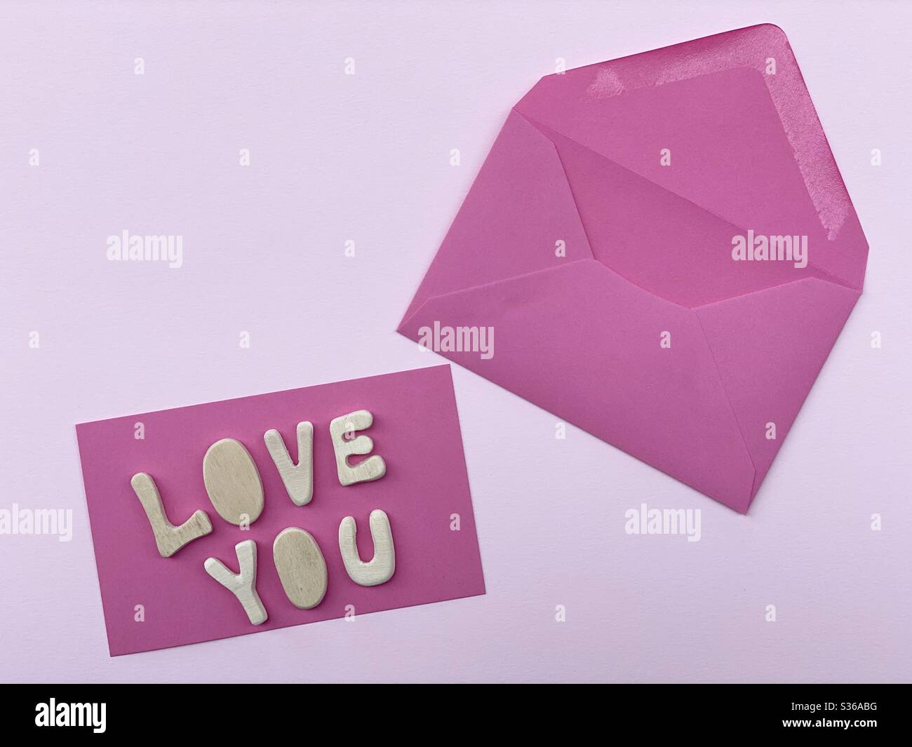 Love you message composed with handmade wooden letters on a pink card Stock Photo