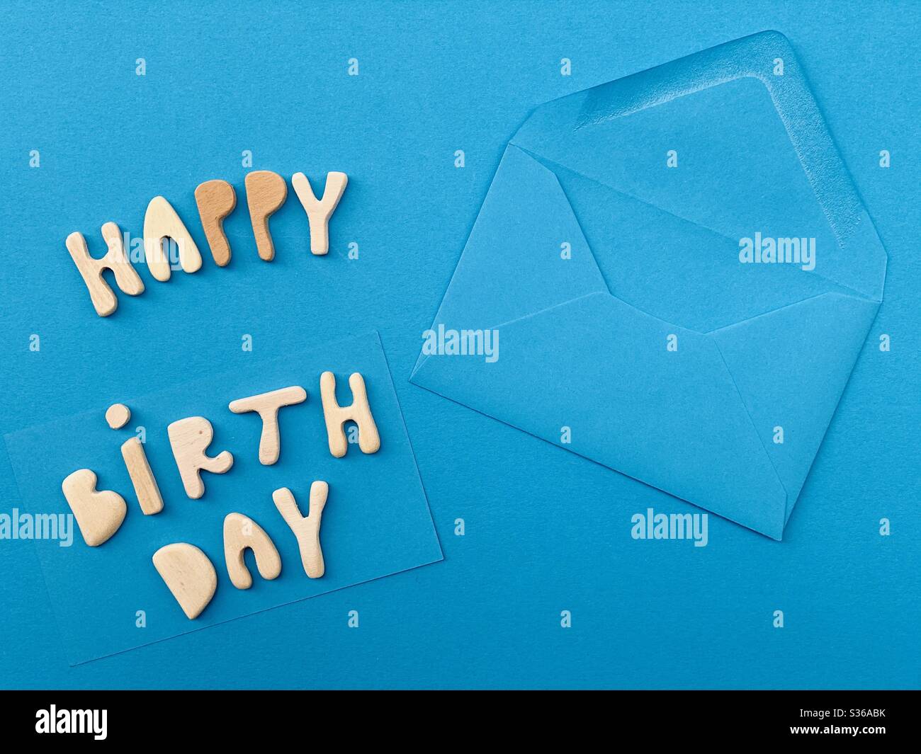 Happy Birthday message composed with handmade wooden letters on a blue card Stock Photo