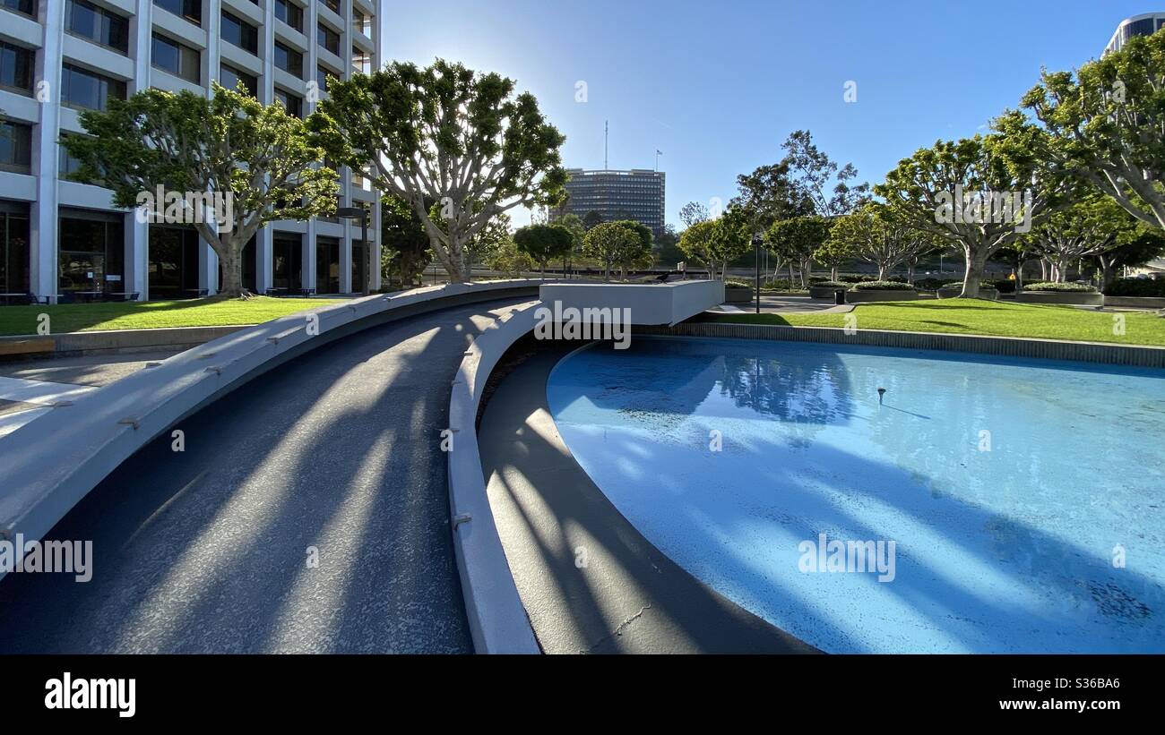 LOS ANGELES, CA, MAY 2020: outdoor park featuring pools of water and landscaped areas at Union Bank Plaza in Downtown, late afternoon with long shadows - Smartphone Captured Stock Image