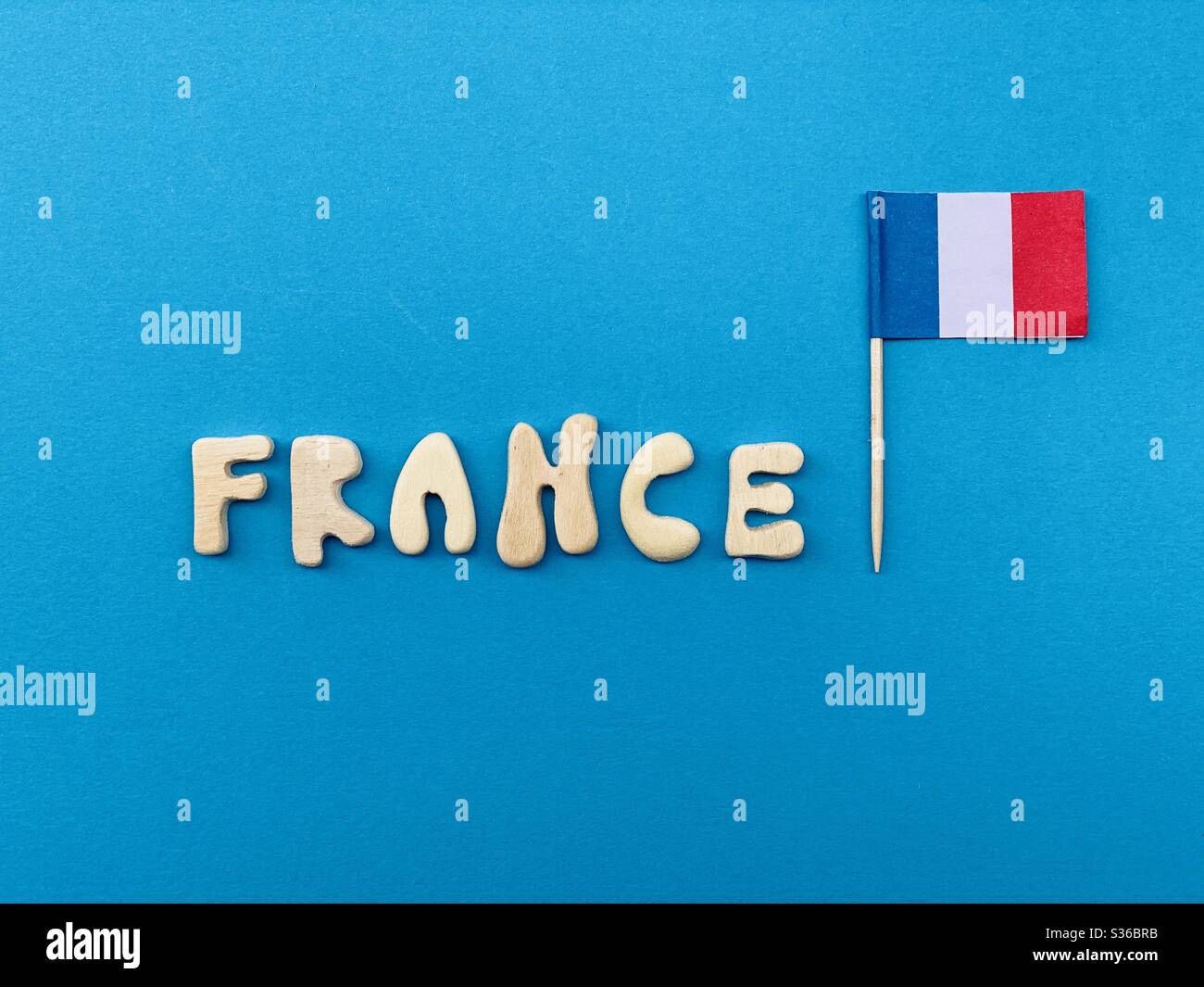 France, souvenir composed with handmade wooden letters over blue color - Smartphone Captured Stock Image