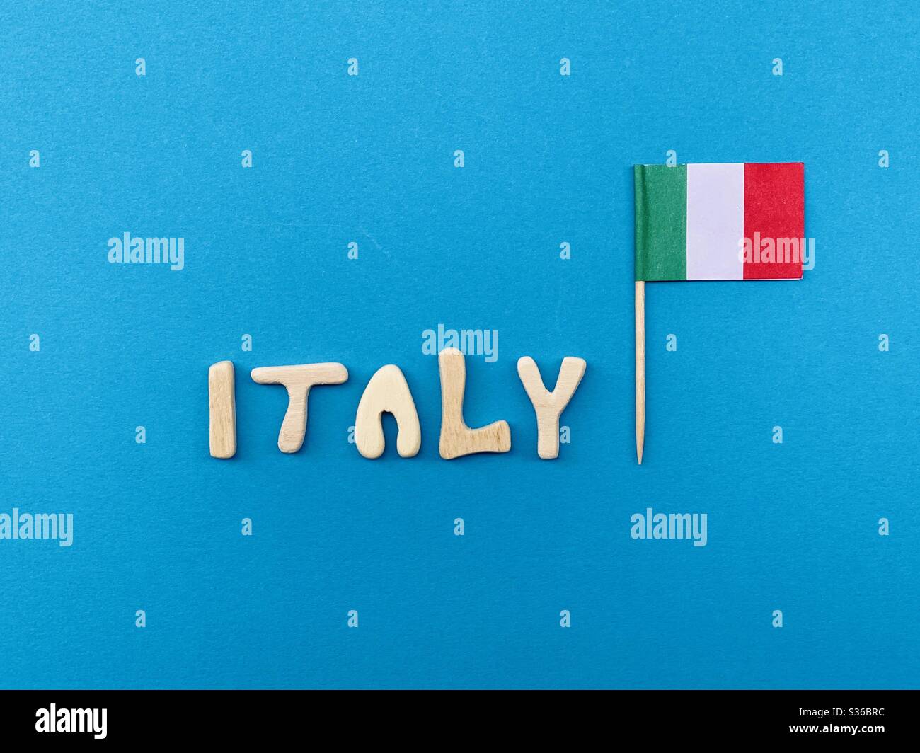 Italy, souvenir composed with handmade wooden letters over blue color - Smartphone Captured Stock Image