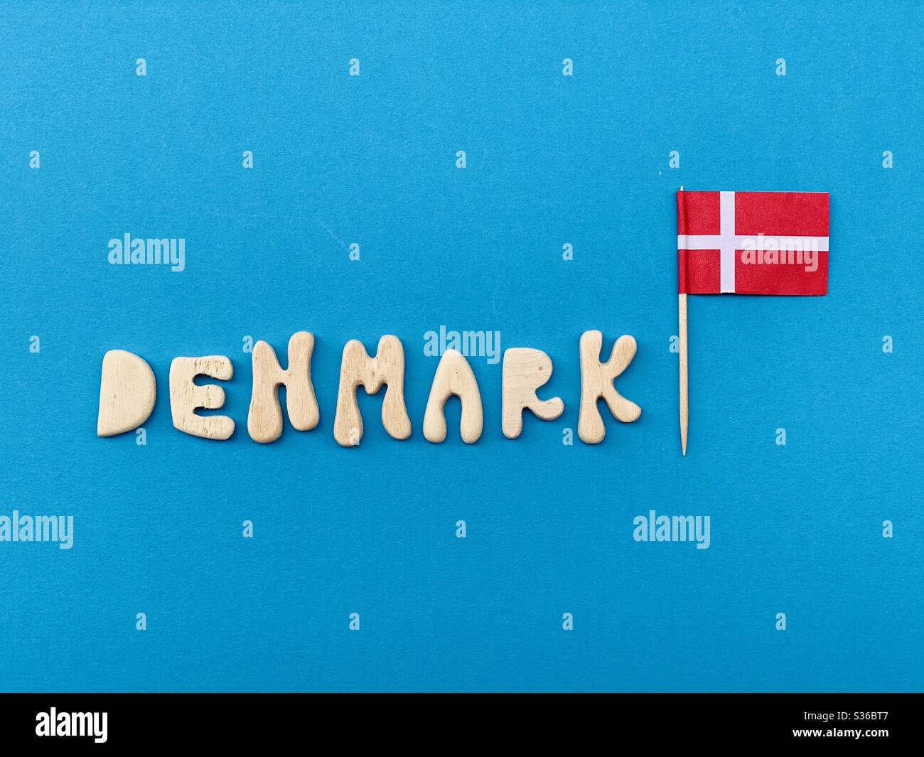 Denmark, souvenir composed with handmade wooden letters over blue color - Smartphone Captured Stock Image