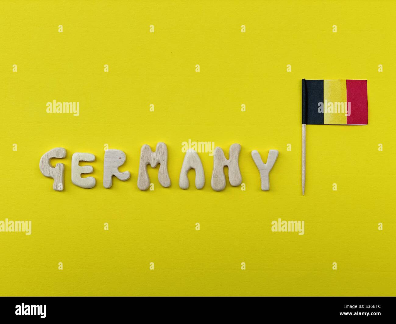 Germany, souvenir composed with handmade wooden letters over yellow color - Smartphone Captured Stock Image