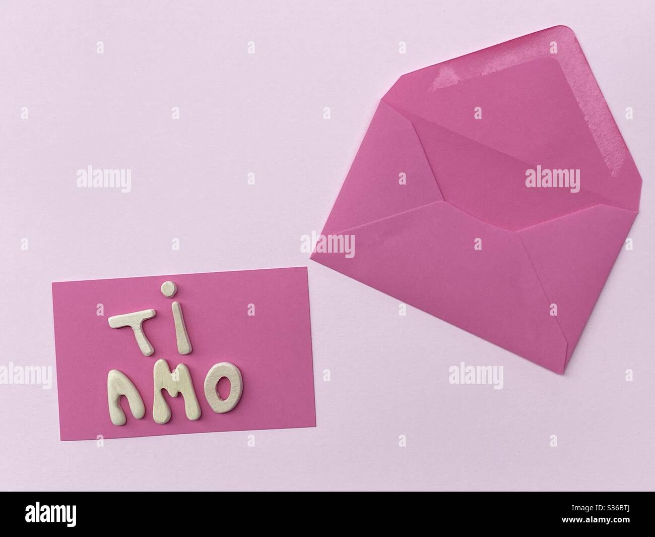Ti amo, I love you composed with handmade wooden letters over pink card Stock Photo