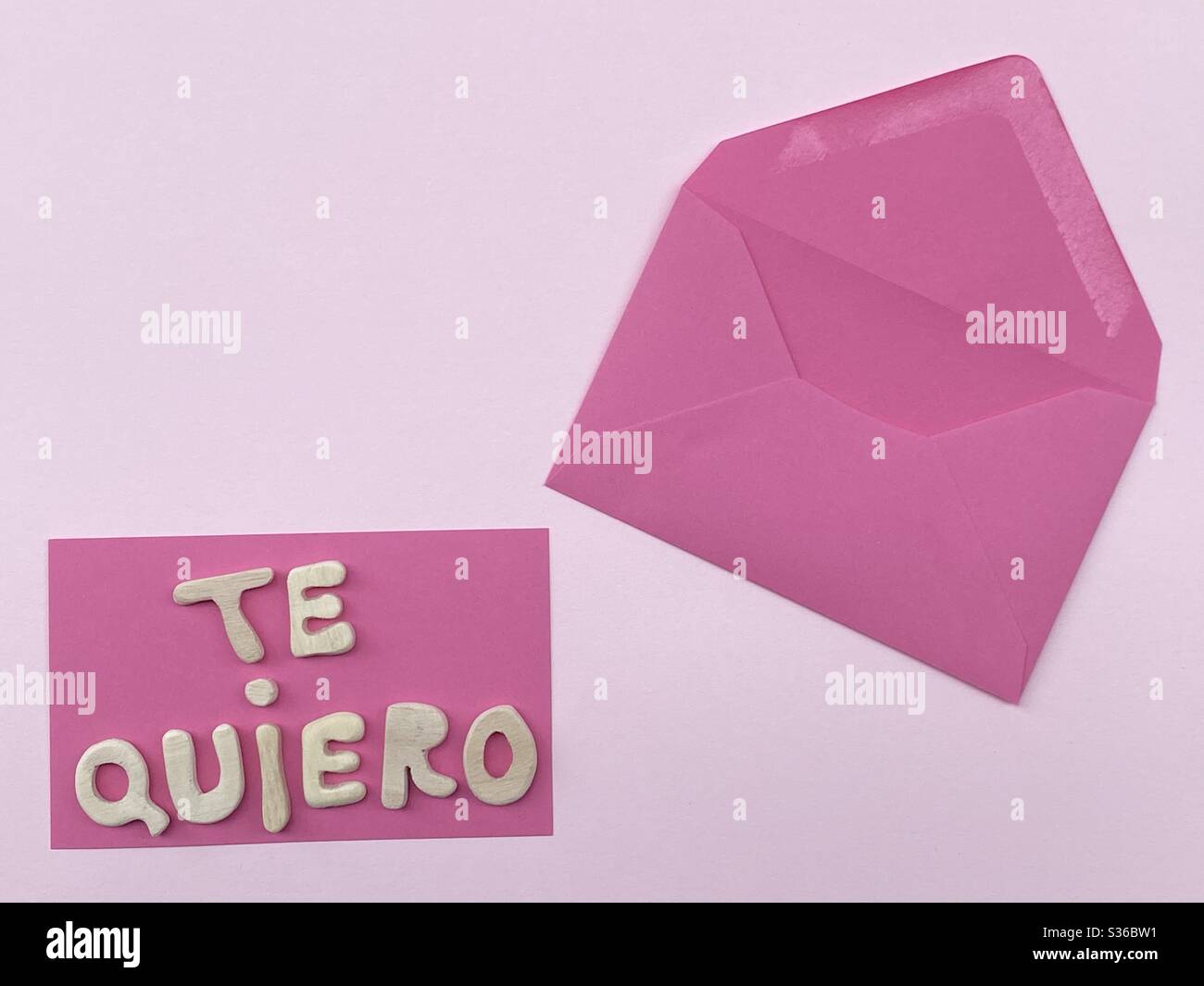 Te quiero, spanish text meaning I love you composed with handmade wooden letters over pink color Stock Photo