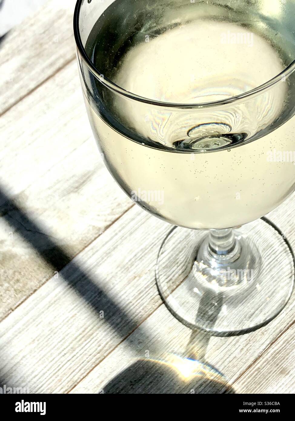 Glass of chilled white wine on a wooden table - Smartphone Captured Stock Image