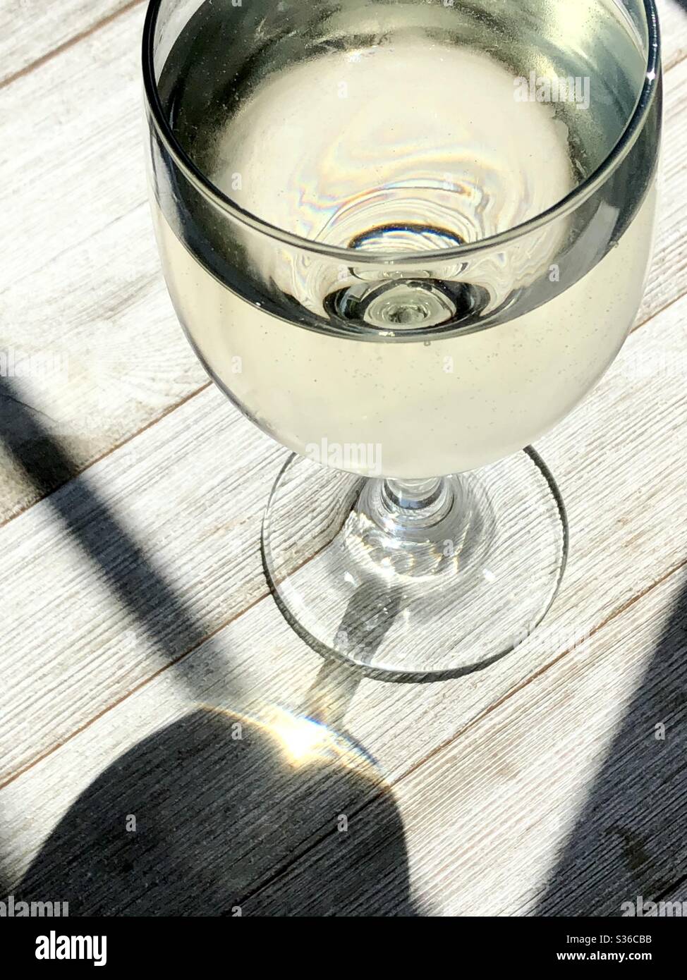 Glass of chilled white wine on a wooden surface - Smartphone Captured Stock Image