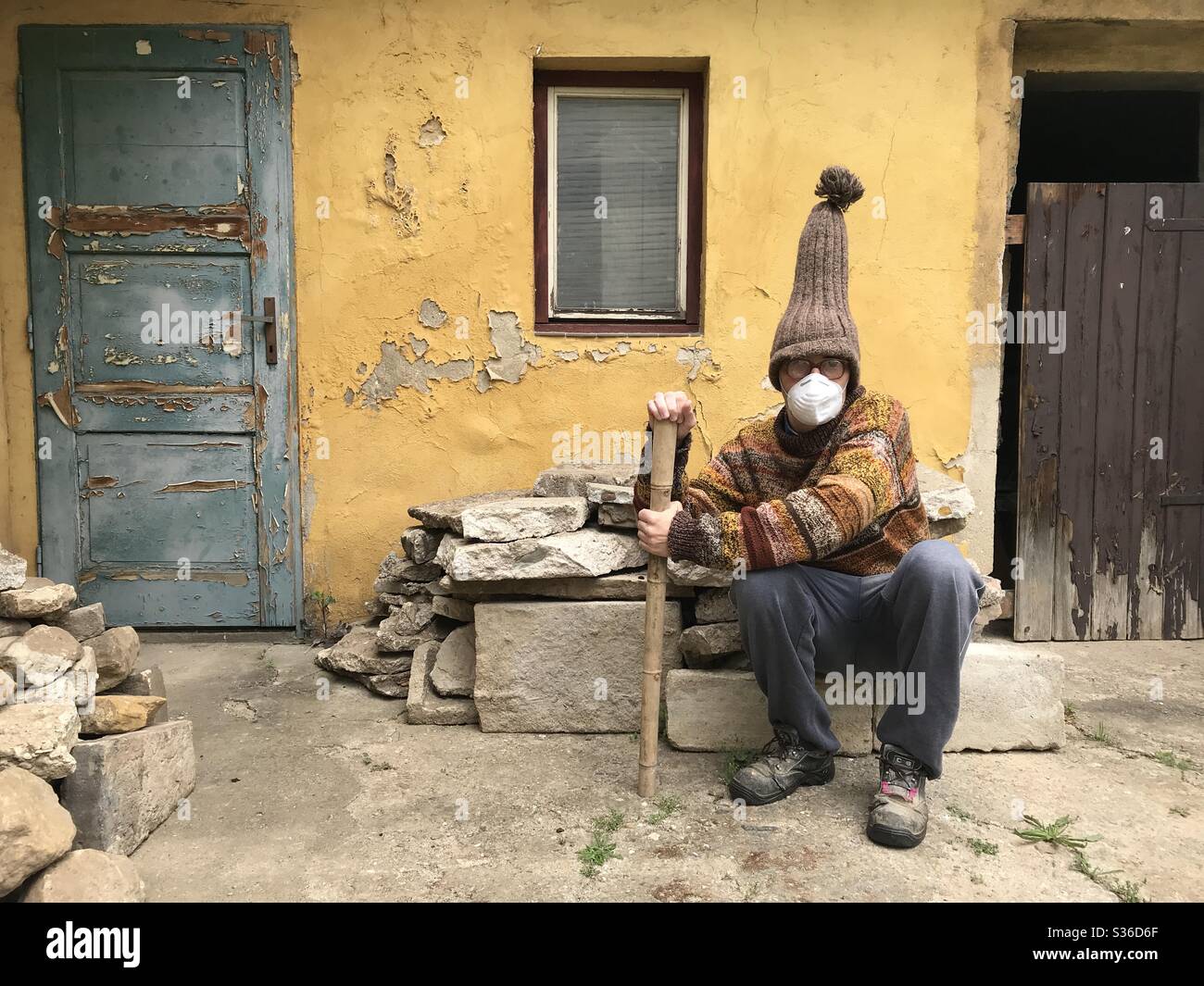 Old Man Spending the Pandemic Time at his Courtyard Stock Photo