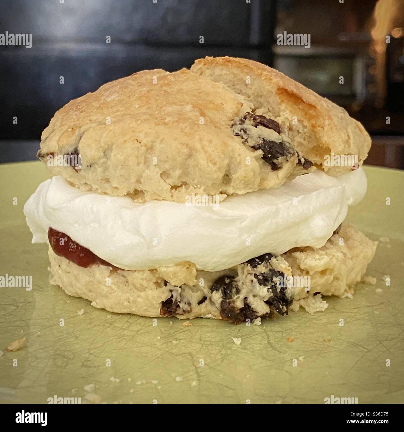 Close up on a fresh, homemade raisin scone with strawberry jam and cream filling - Smartphone Captured Stock Image