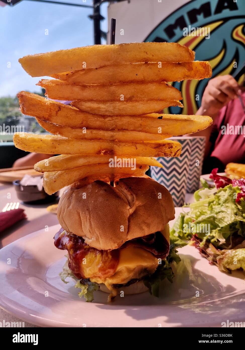 A juicy cheeseburger with fries. - Smartphone Captured Stock Image