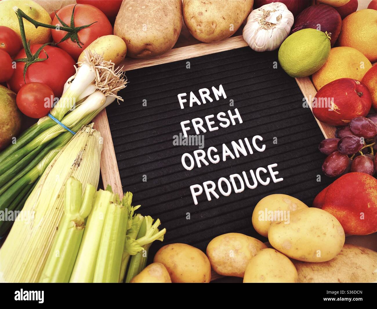 Farm fresh organic produce sign against a rustic background of fresh fruit and vegetables. Farmers market ingredients. Locally sourced, organic and healthy veggies. - Smartphone Captured Stock Image