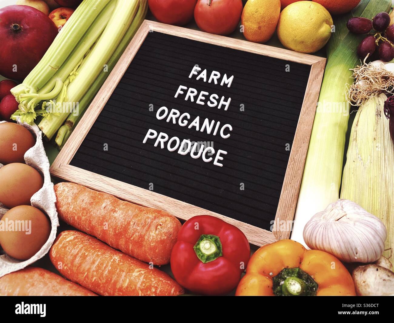 Farm fresh organic produce sign against a rustic background of fresh fruit and vegetables. Farmers market ingredients. Locally sourced, organic and healthy veggies. - Smartphone Captured Stock Image