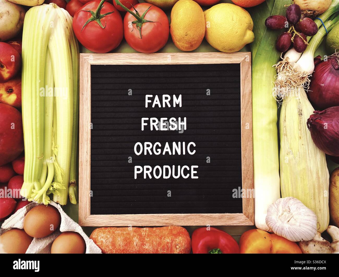 Farm fresh organic produce sign against a rustic background of fresh fruit and vegetables. Farmers market ingredients. Locally sourced, organic and healthy veggies. - Smartphone Captured Stock Image