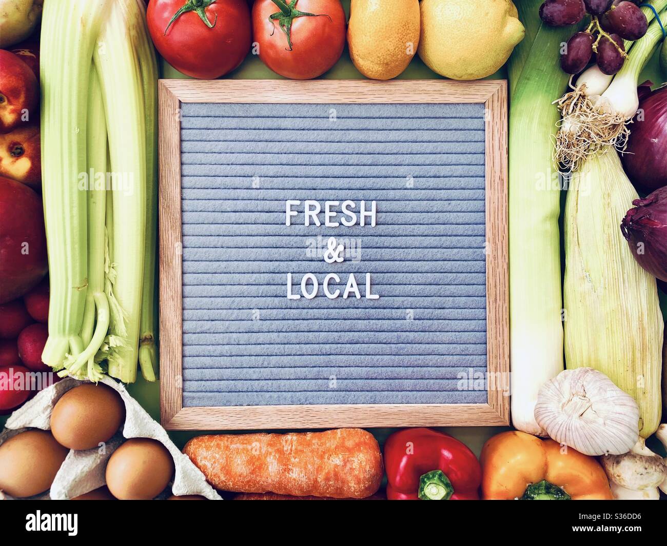 Fresh and Local sign against a colorful background of fresh fruit and vegetables. Farmers market ingredients. Locally sourced, organic and healthy veggies. - Smartphone Captured Stock Image