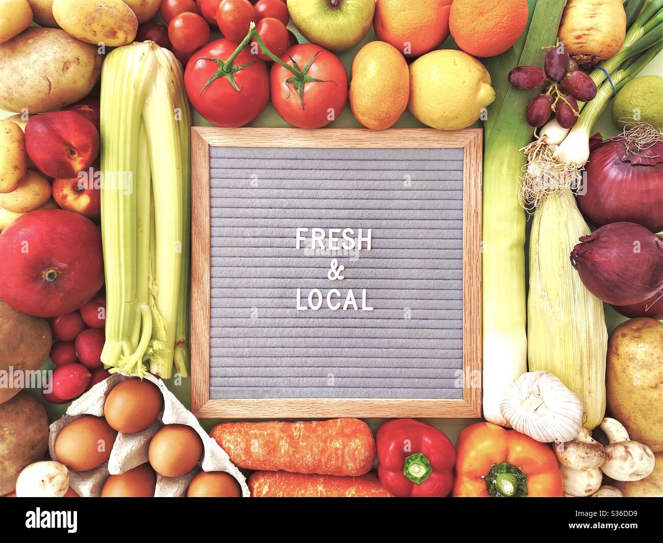 Fresh and Local sign against a colorful background of fresh fruit and vegetables. Farmers market ingredients. Locally sourced, organic and healthy veggies. - Smartphone Captured Stock Image