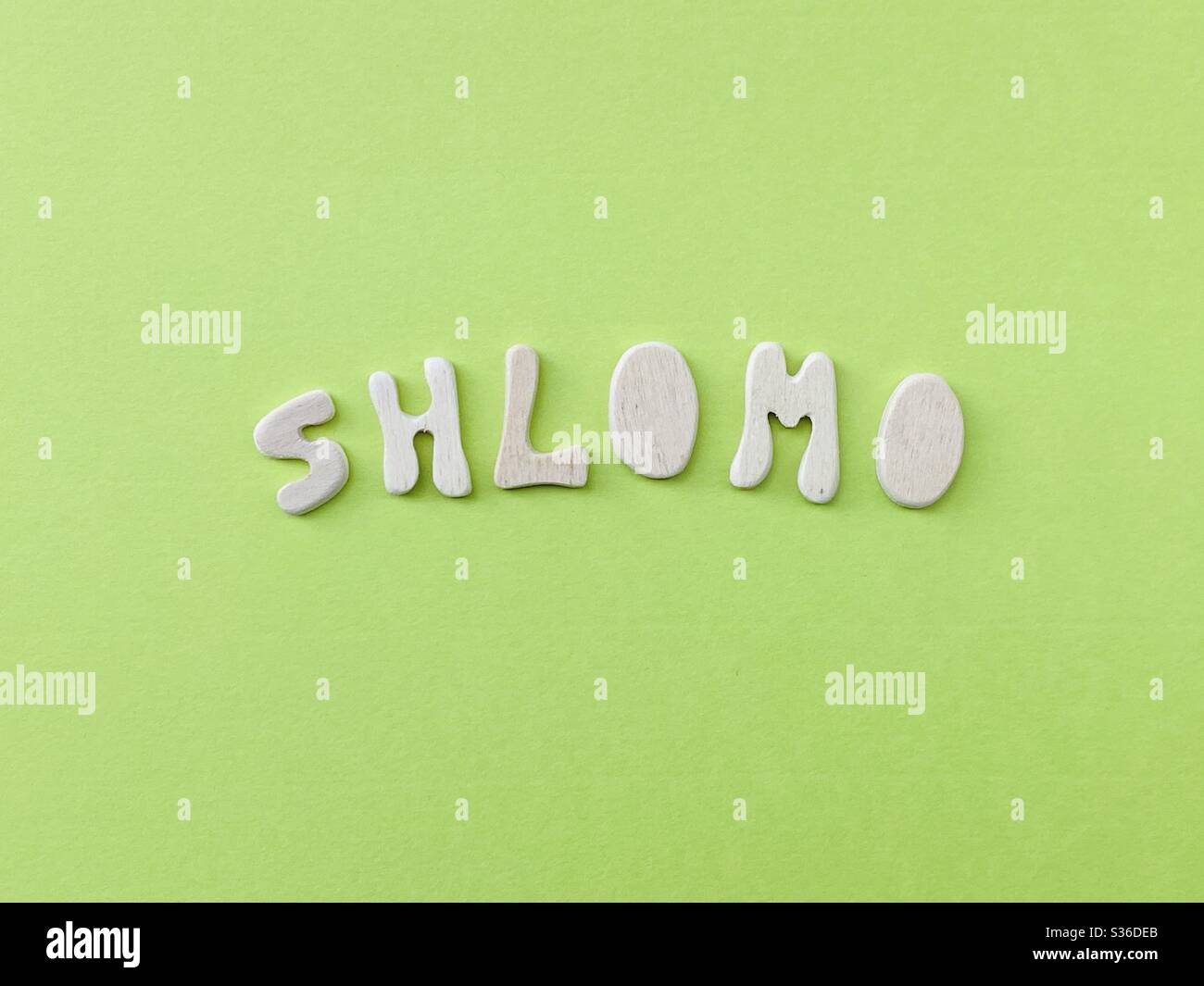 Shlomo, common Hebrew male given name composed with handmade wooden letters over green color - Smartphone Captured Stock Image